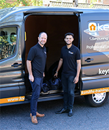 two keytek locksmiths standing outside work van